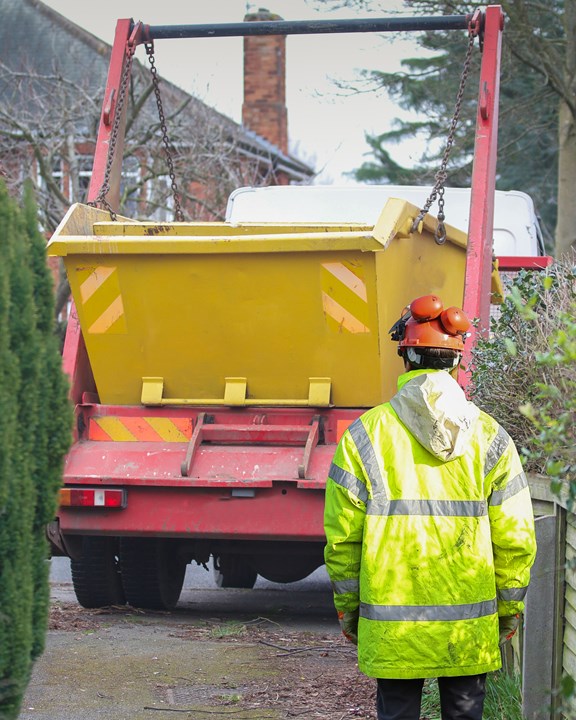 Person In Hi Vis With Skip Lorry